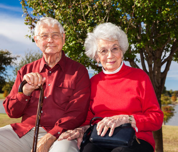 senior couple sitting on park bench