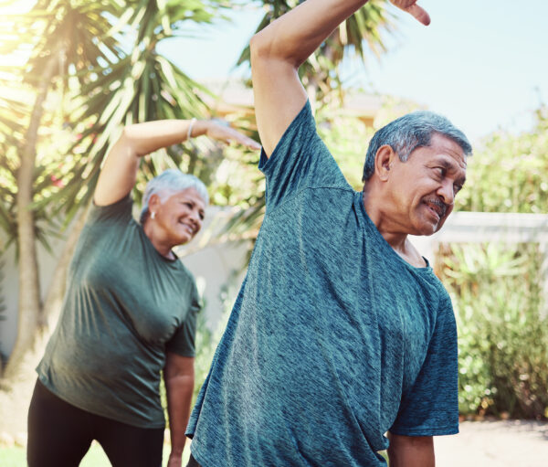 Fitness, yoga and health with a senior couple outdoor in their garden for a workout during retirement. Exercise, pilates and lifestyle with a mature man and woman training together in their backyard